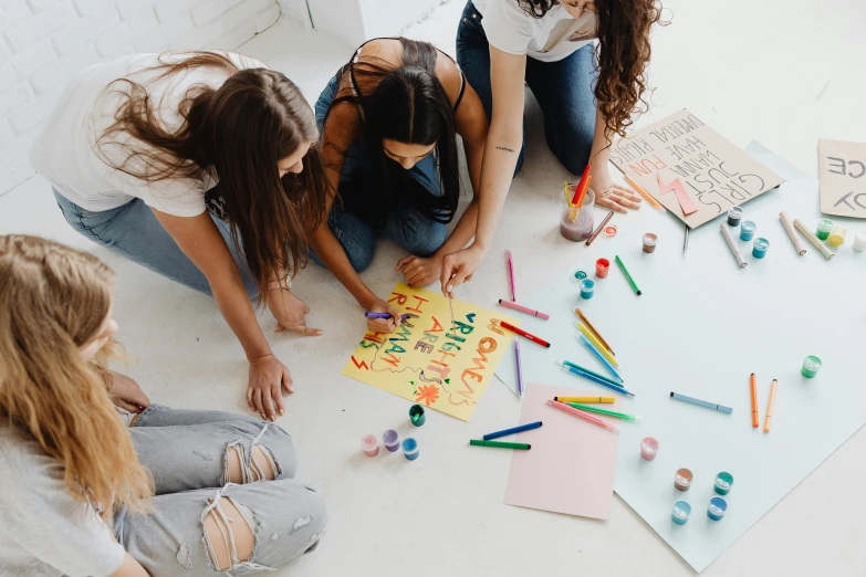 girls sitting on the floor playing with magnets and crayons