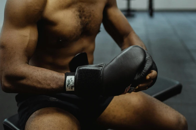 a man sitting in a chair while holding a boxing glove