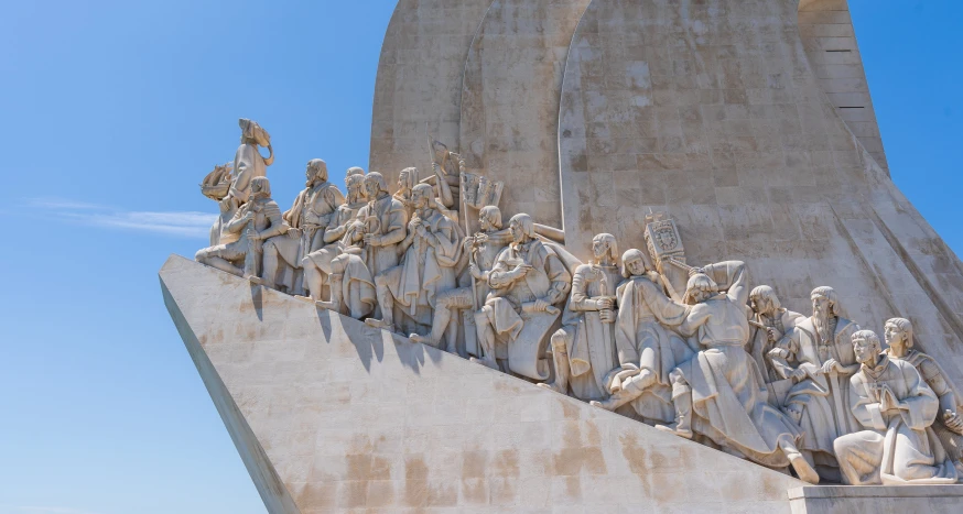 a large sculpture made of people and horses in front of the monument