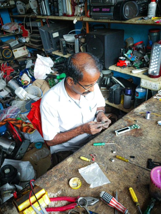 a man sitting at a desk working on soing