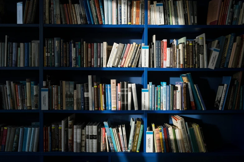 a bookshelf with many books and an illuminated book light
