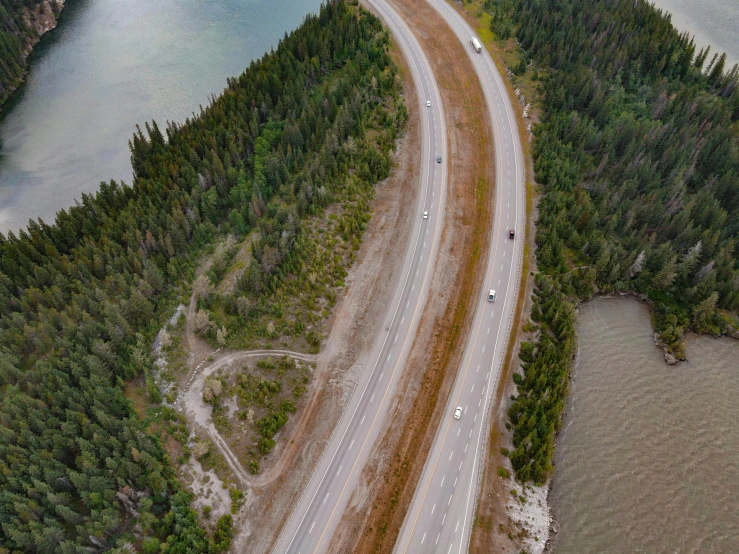 aerial view of a curving road near a lake