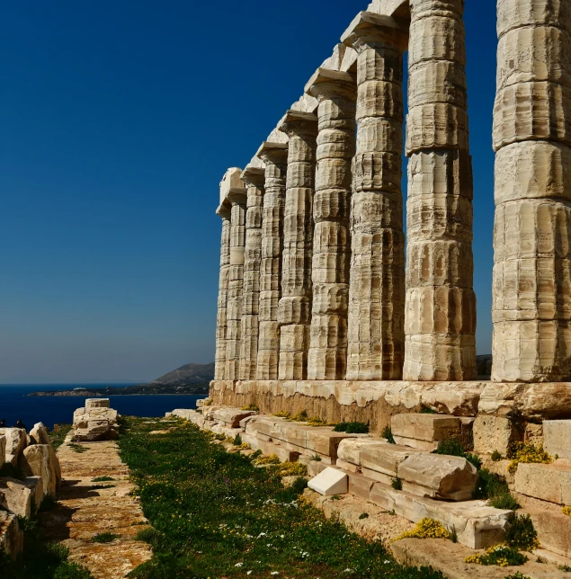 some stone pillars are standing against a beautiful blue sky