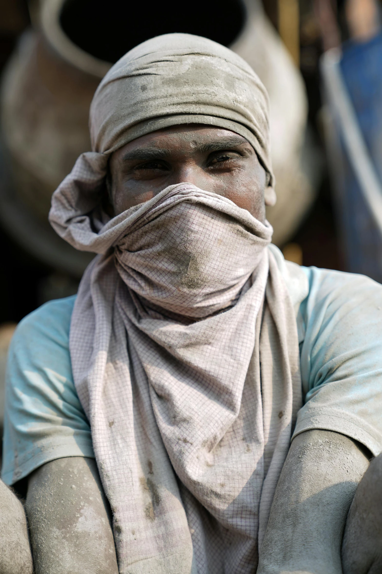 the man wears a grey head cover and white scarf