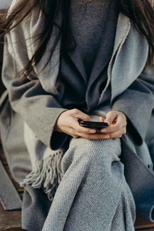 a woman sitting with a cell phone on her lap