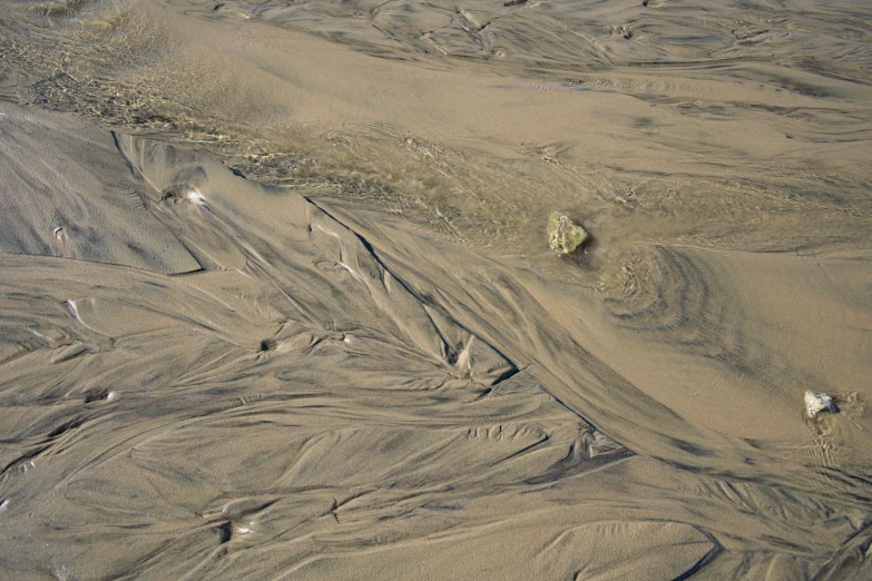 sand and water creating a pattern on a beach