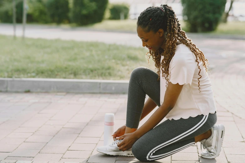 a woman is sitting on the ground rubbing her feet