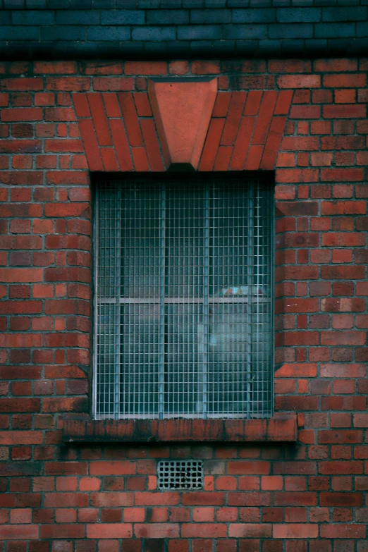 the window is behind bars on a red brick building