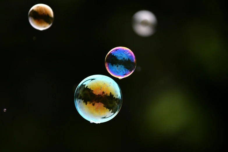 soap bubbles floating in the air with one showing blue and the other red