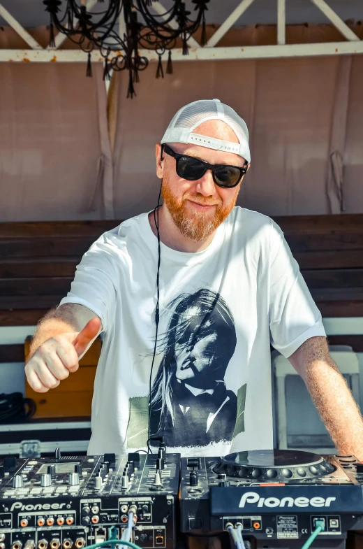 a man with sunglasses and headphones in front of a mixer