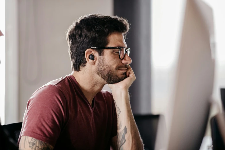 a man looking at a computer screen wearing glasses