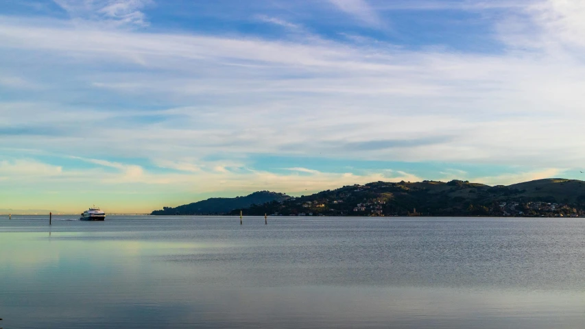 a small sailboat sails along the ocean