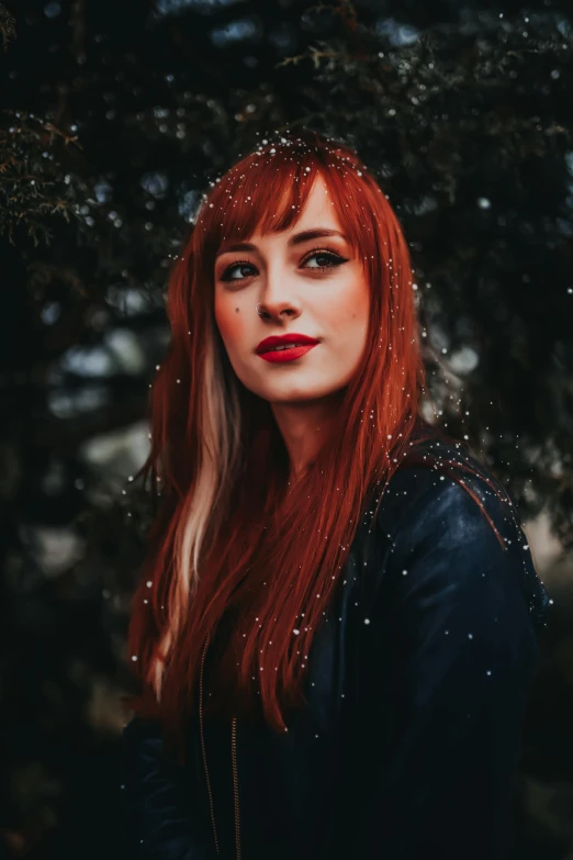 a woman with long red hair and a black shirt is posing