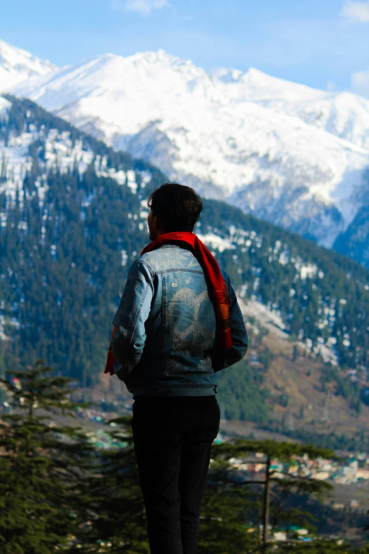 a man with a backpack stands at the base of a mountain