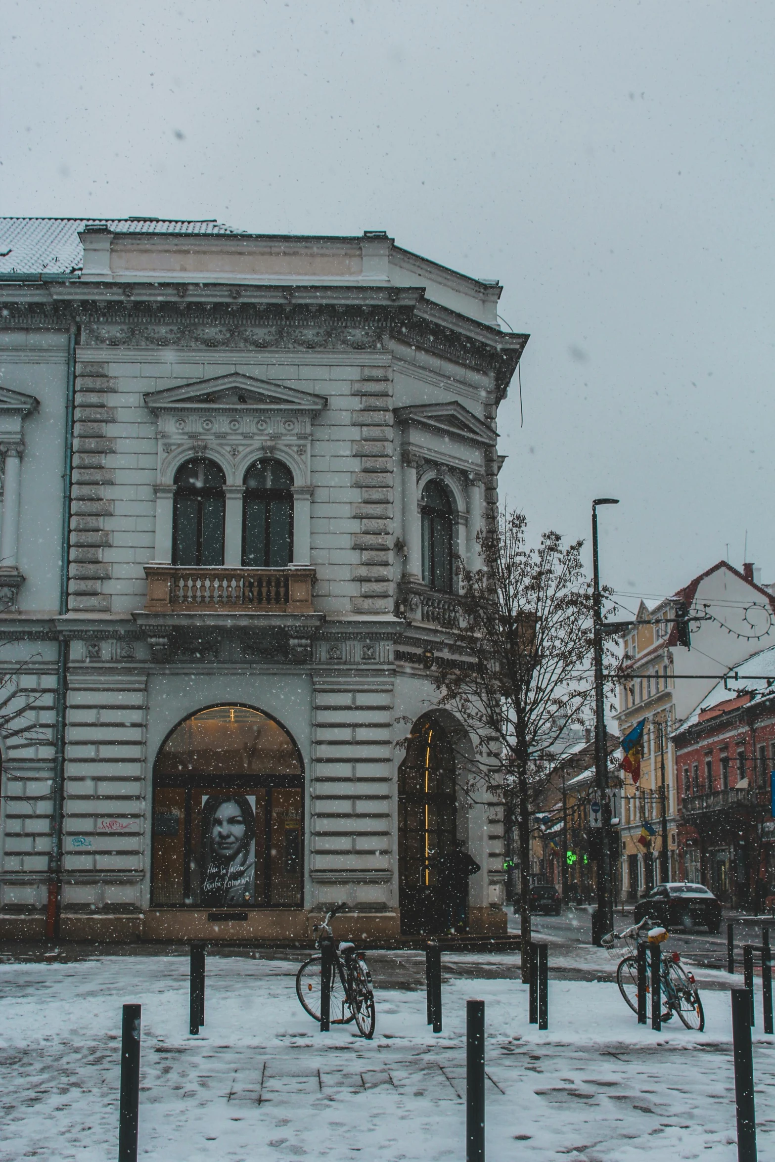 a snowy day at an old fashioned store with a bike parked outside