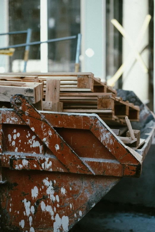 a stack of wooden lumber sits outside of a building