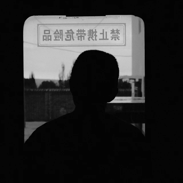 a man with a phone standing next to a sign