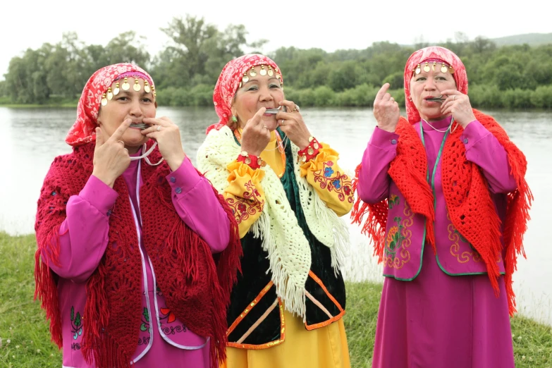 three beautiful women standing near water smoking a cigarette