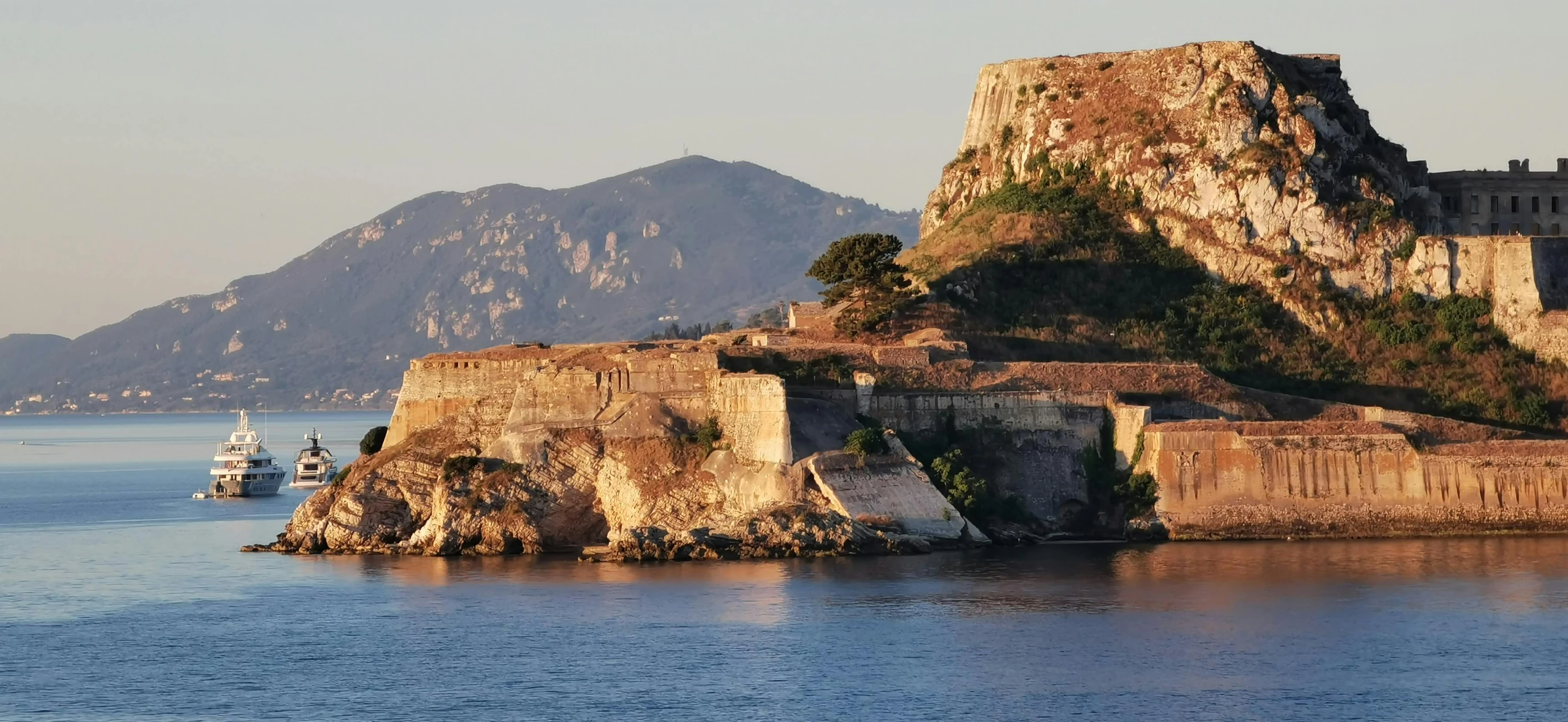 a castle on an island with a yacht on the water