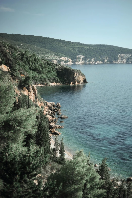 a body of water with cliffs and trees next to it