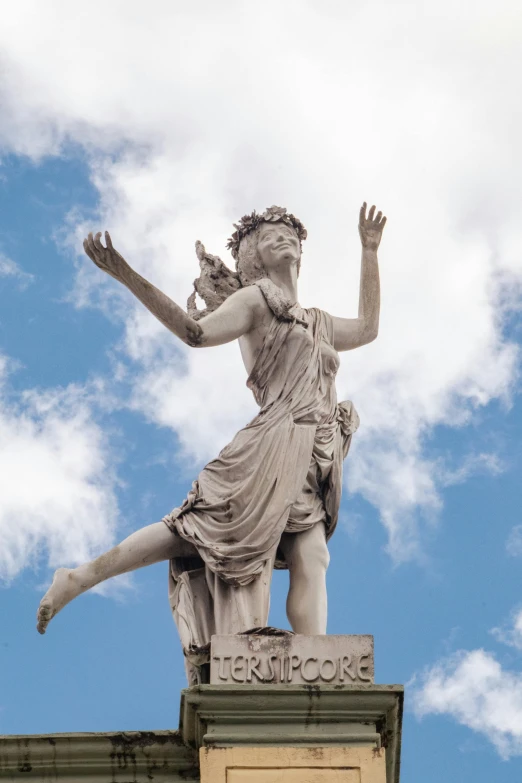 a statue on top of a pillar next to the blue sky