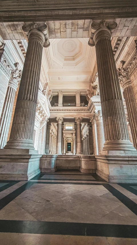 an elegant hall with four marble columns and two urns