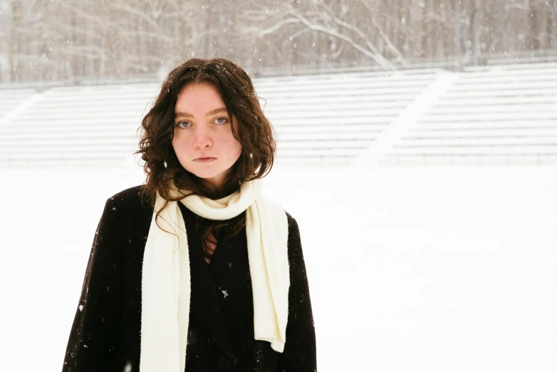 a woman in a black sweater standing in the snow