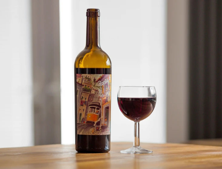 a bottle and glass of wine on a wooden table