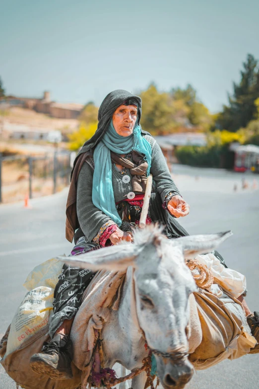 a woman is riding a donkey while wearing a hat