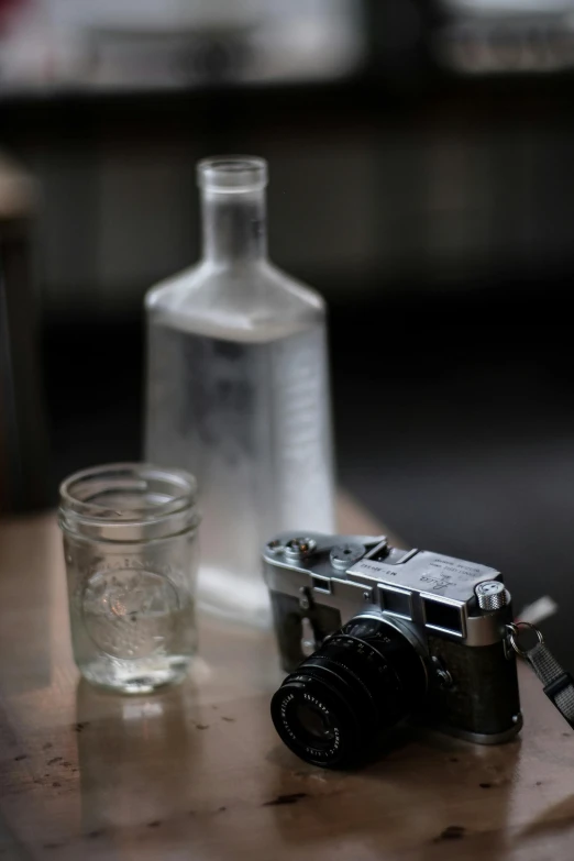 the image shows a camera, a bottle and some glasses