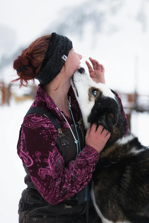 woman in purple jacket with black and white dog