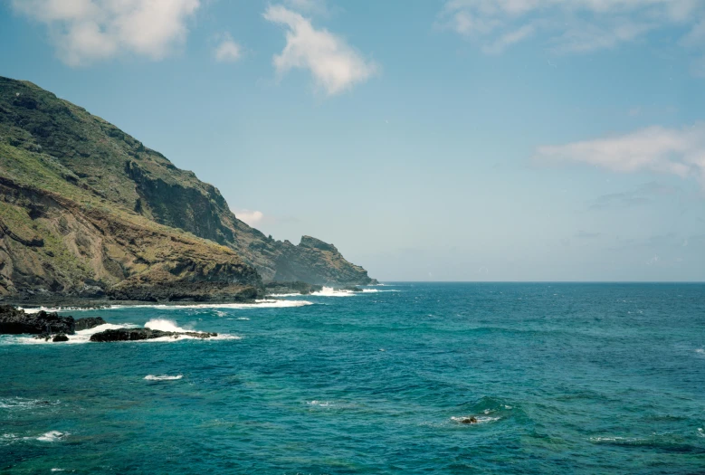 the sea is blue and green near an island