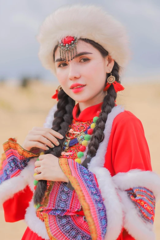 the woman is posing on the sand in her costume