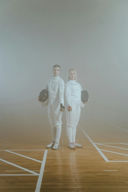 two young people wearing white standing together in a foggy space