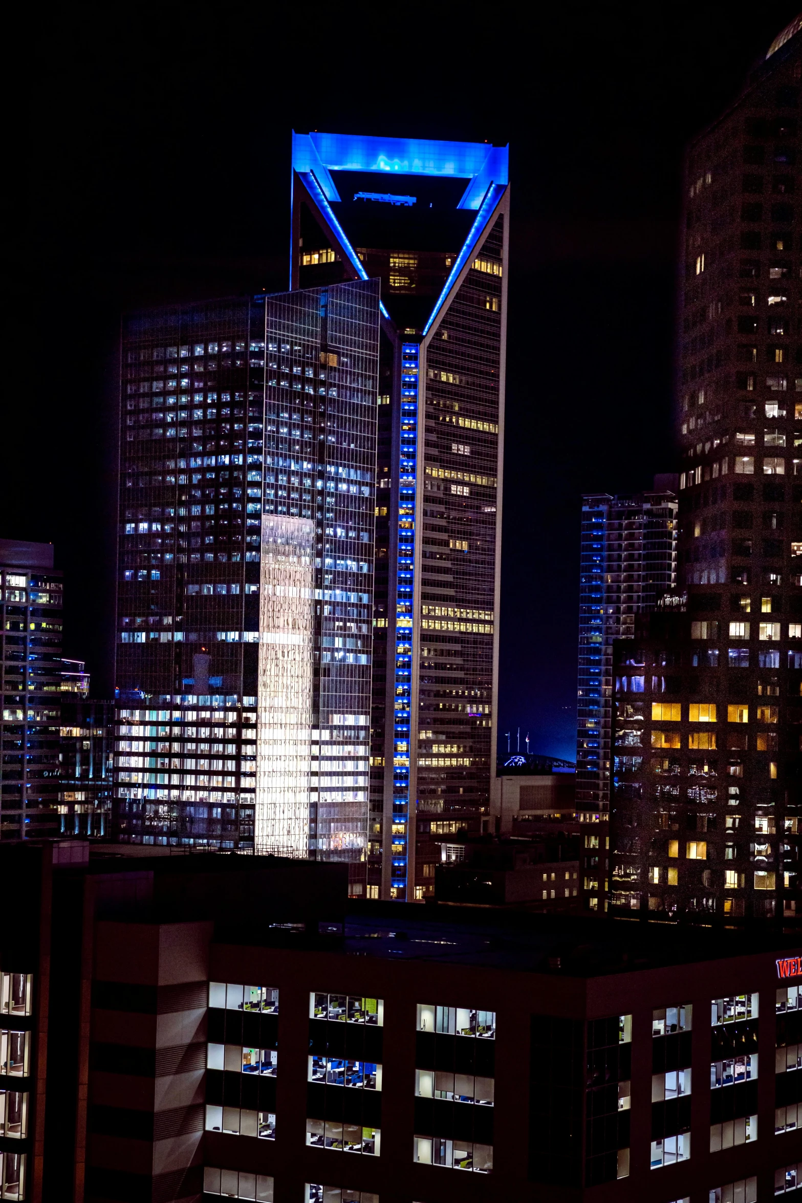 a very tall building with blue lights in a city