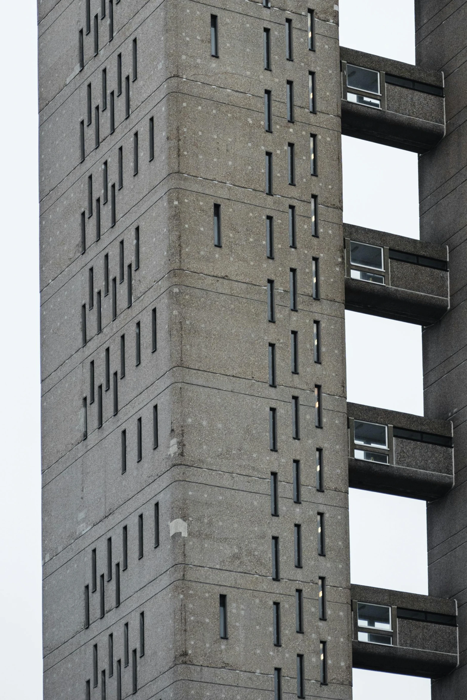 the side of a building with several windows and balconies on each side