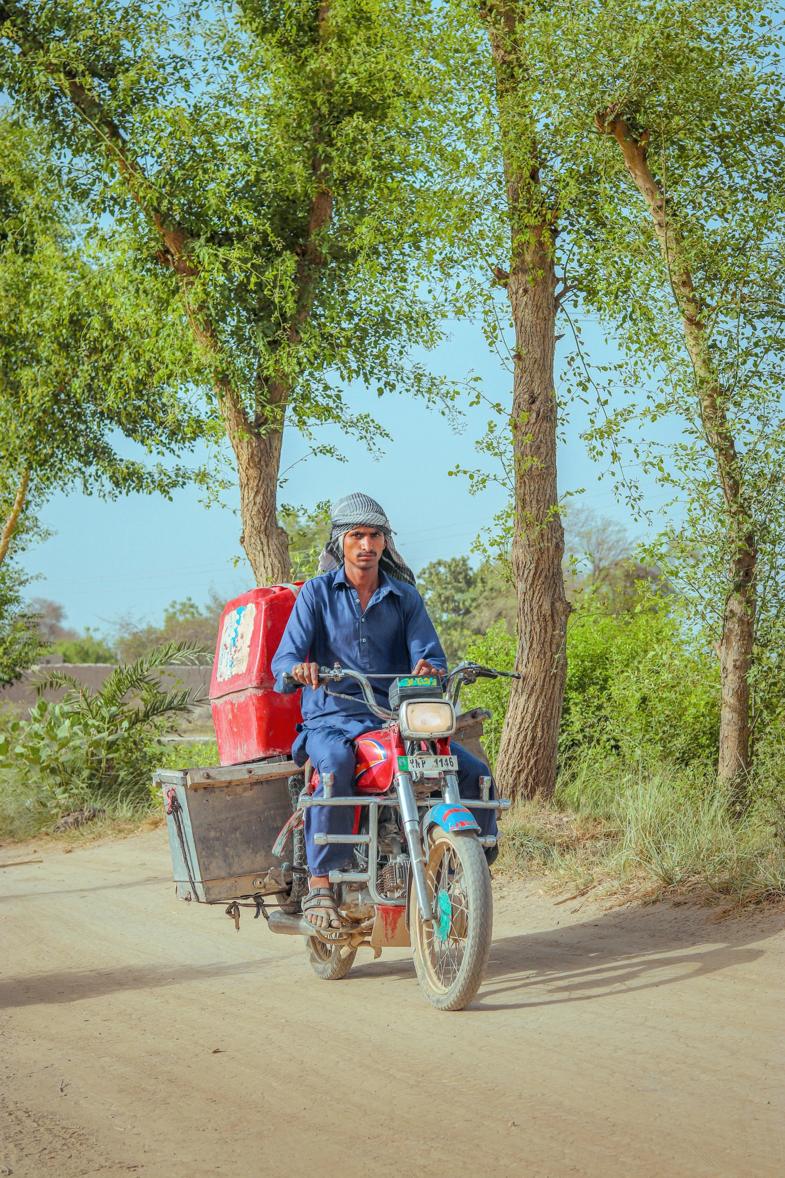 a man riding a motorcycle with a cooler attached