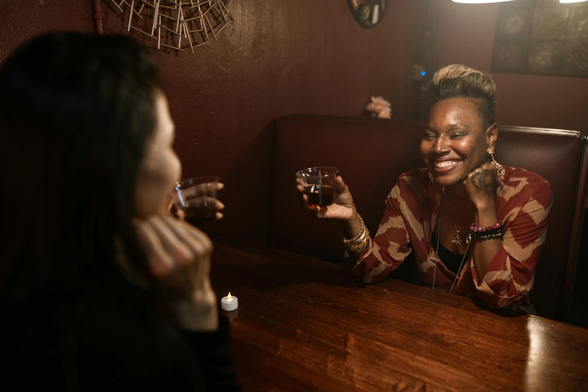 two women smiling and laughing in a restaurant