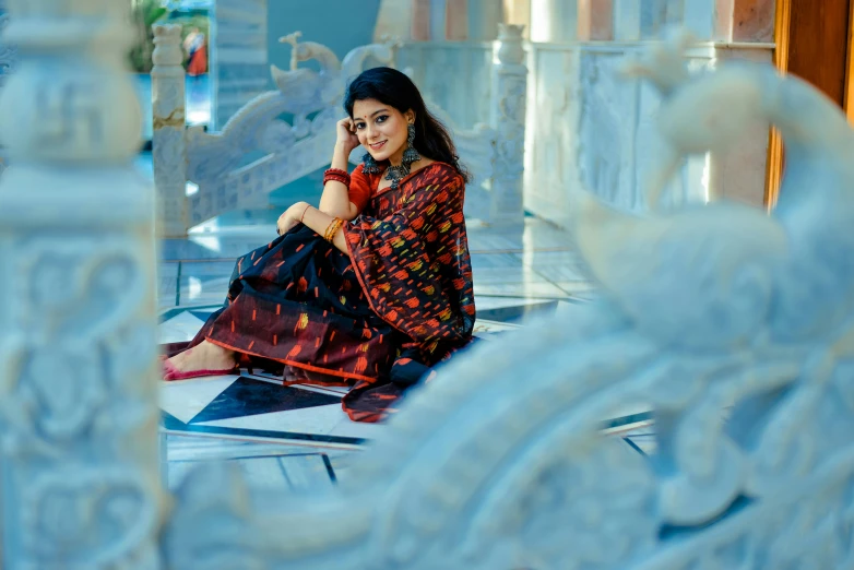 a woman sitting in front of a mirror with her cell phone