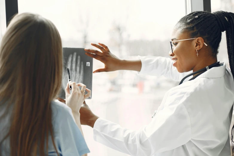 woman and woman in white coat touching cards