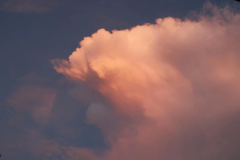 a plane flies high in the air as the clouds fill the sky