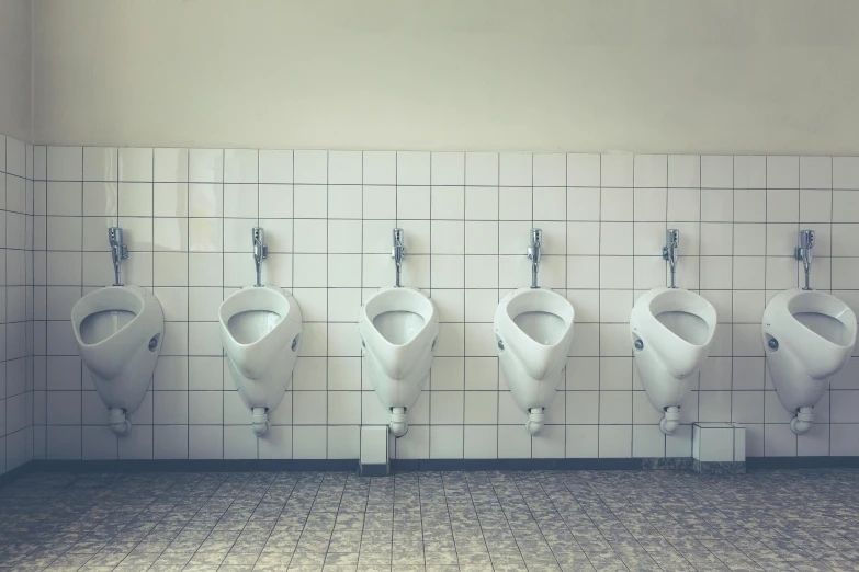 the urinals of the men's bathroom are in different shapes and sizes