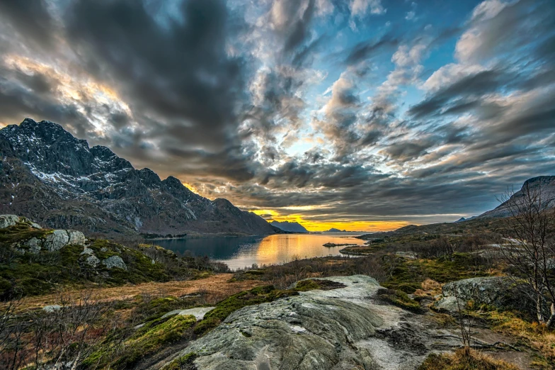 a rocky landscape near a body of water under a cloudy sky