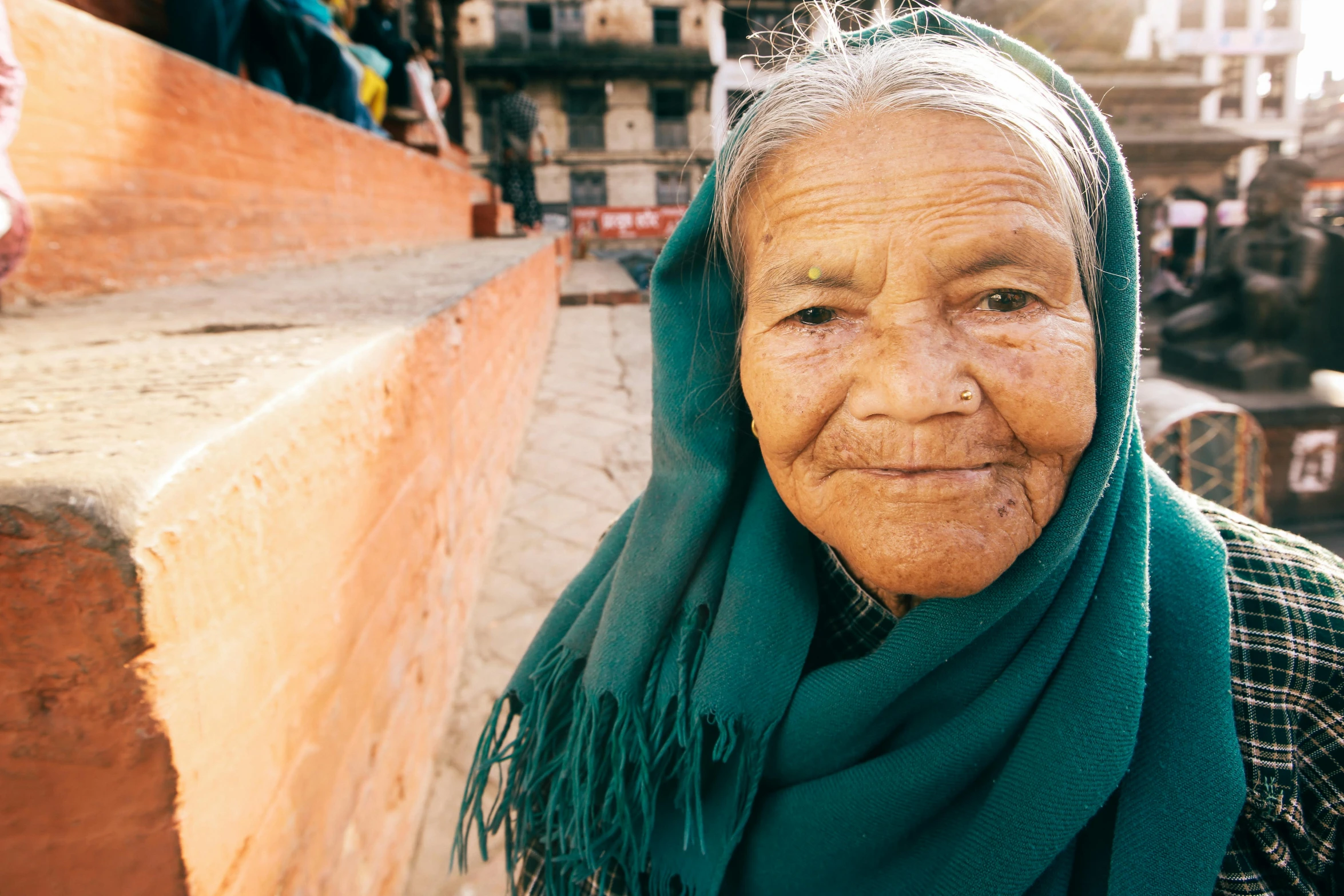 an elderly woman standing in front of a street