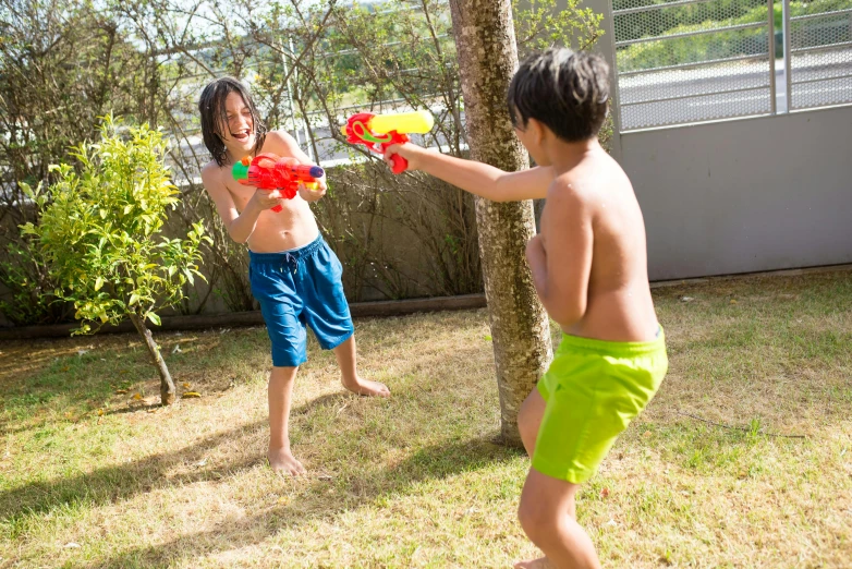 two children playing with an orange and red toy