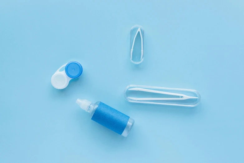 a bottle of liquid sitting next to some tools on a blue background