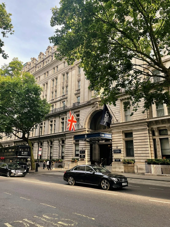 cars parked at the corner of a street next to tall buildings