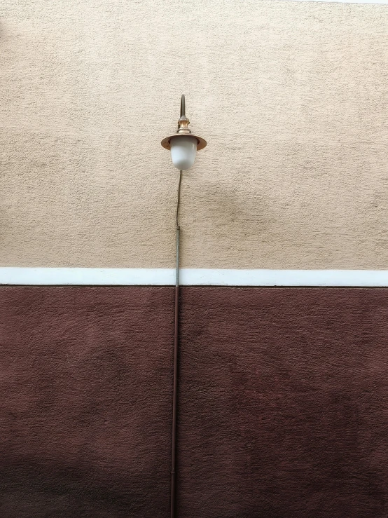 a light in front of a wall on a pole