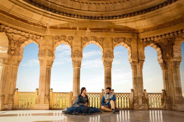 two people sitting in front of a large building