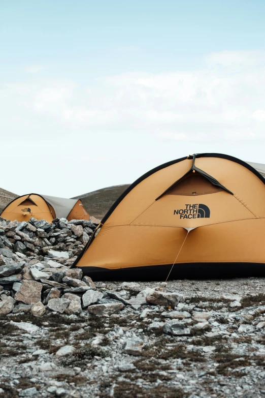 an orange tent is set up in the wilderness